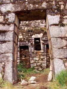 View in the front door of Inca Wasi, showing internal trapezoidal nooks, central internal window, and broken roofpegs in doorway